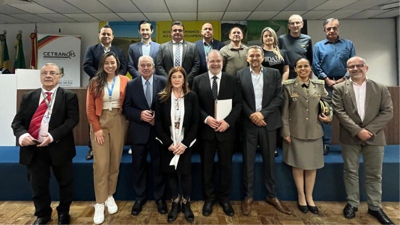 Foto horizontal colorida mostra grupo de homens e mulheres posando para a foto sorrindo