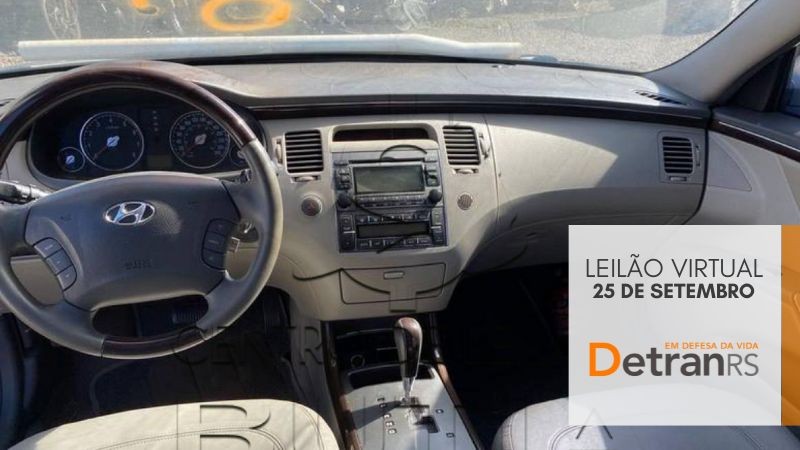 Painel interno do Hyundai Azera, todo em cinza, câmbio automático, voltante com controles de som e bancos em couro