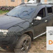 SUV Renault Duster preta com detalhes em cinza e box cinza com faixa laranja na lateral onde está escrito leilão virtual 09 de outubro detranrs em defesa da vida