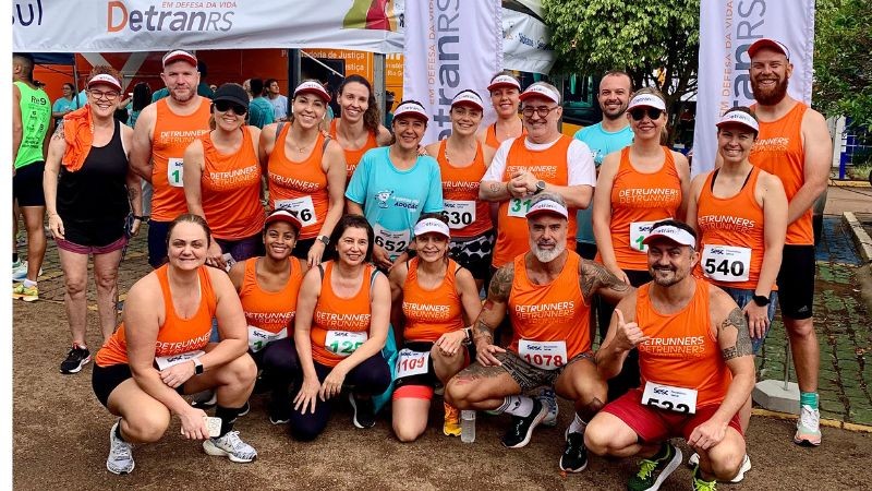 servidores do detran de regata laranja posam para foto oficial