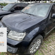 grand vitara preto ao lado de outro veículo preto em um pátio de um depósito de veículos