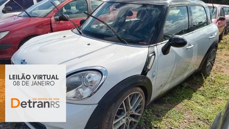 mini cooper branco quatro portas estacionado ao lado de peugeout vermelho em um depósito e box cinza onde está escrito leilão virtual 08 de janeiro