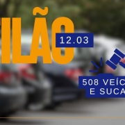 Card com imagem desfocada ao fundo de veículos estacionados lado a lado e em frente está escrito leilão, 12/03, 508 veículos e sucatas